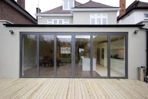 Dark grey bifold doors leading out to wood decking
