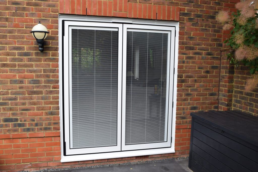 White bifold doors within a brick wall